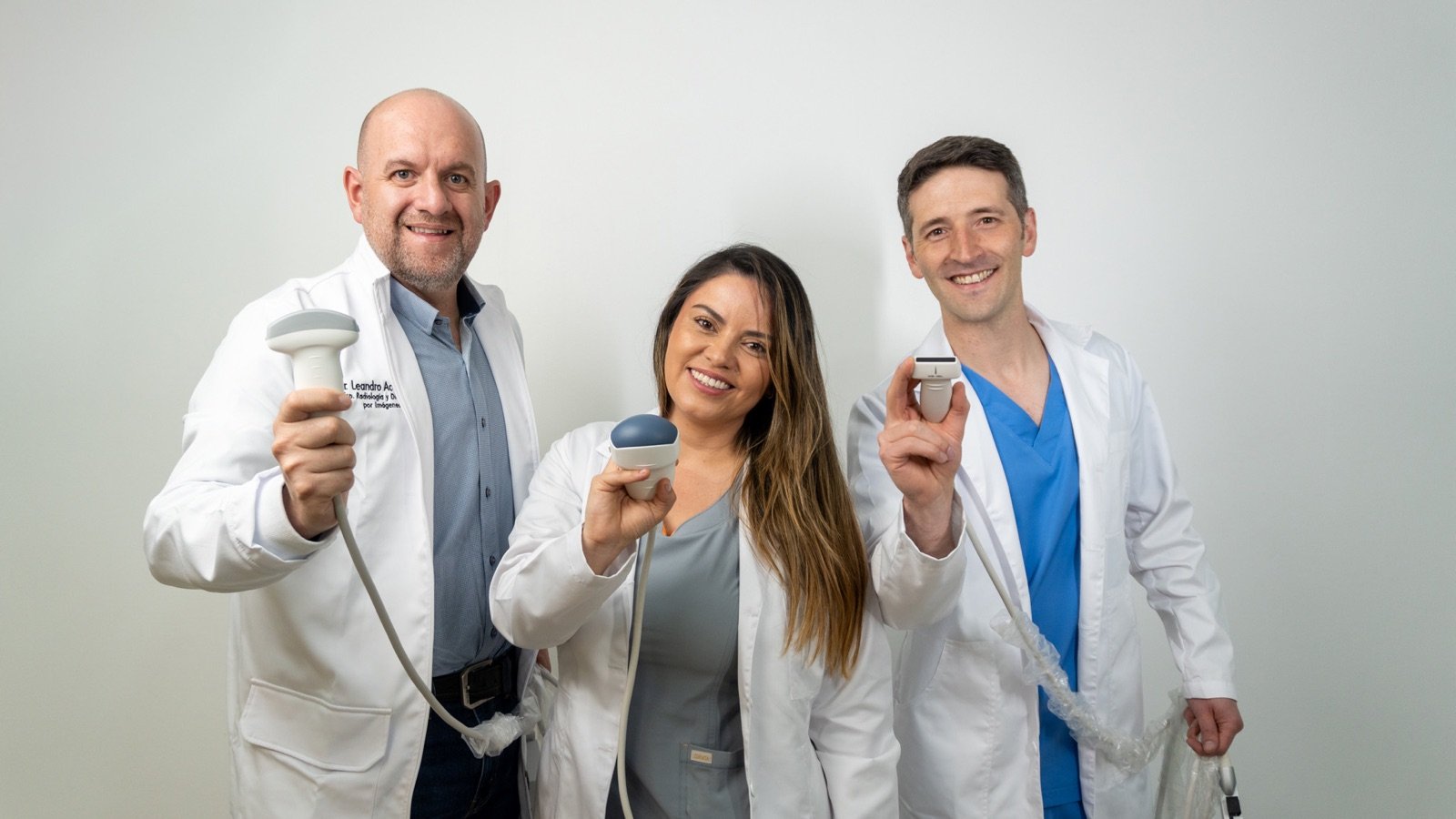 Los tres médicos de ABP Radiólogos sosteniendo transductores de ecografía